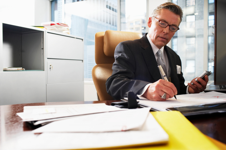 Businessman writing at desk, low angle view